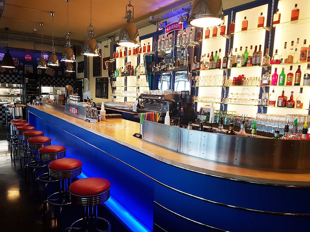 Bar im Metropolitan mit blauem Tresen und roten Barhockern